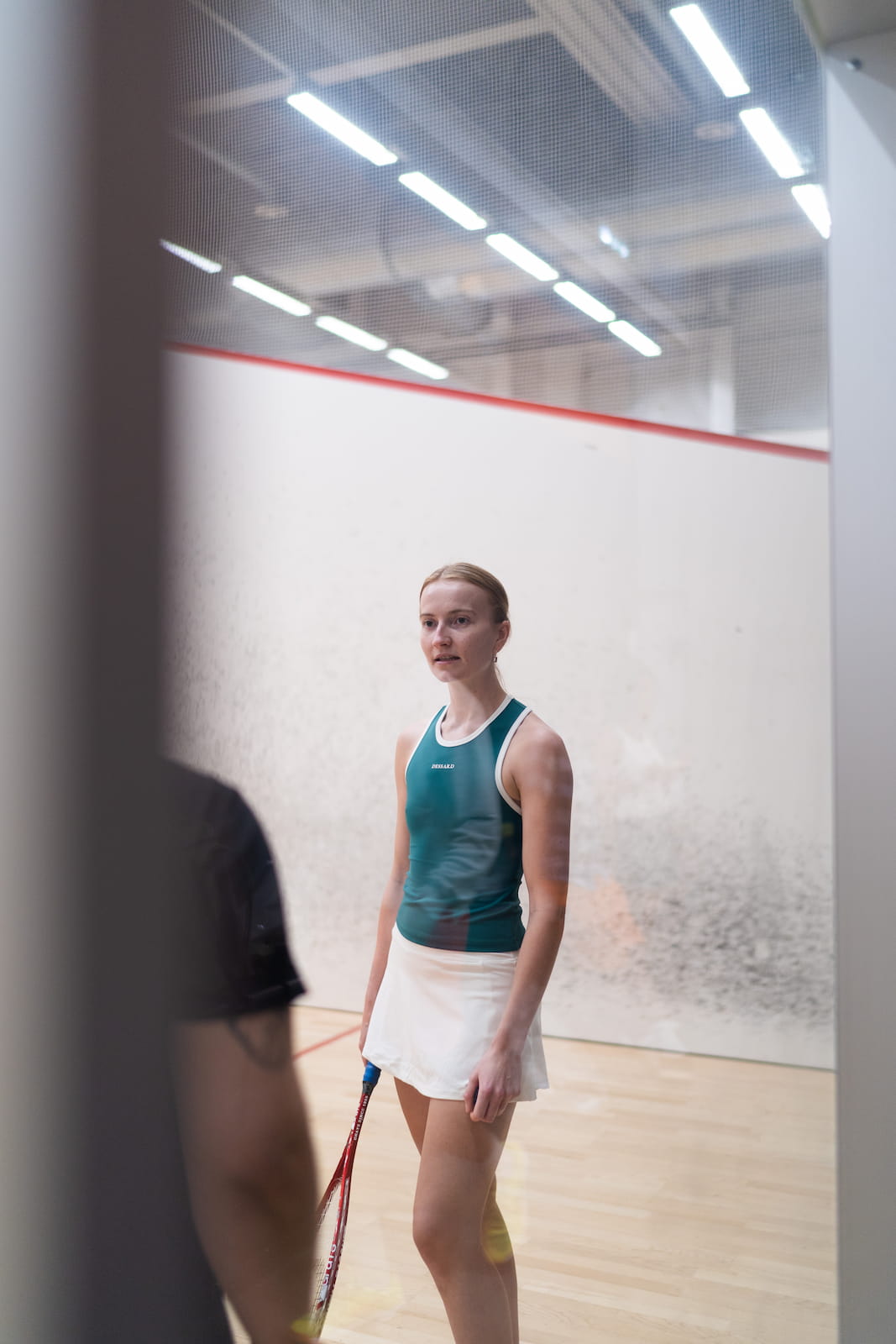 Woman playing squash in Dessard